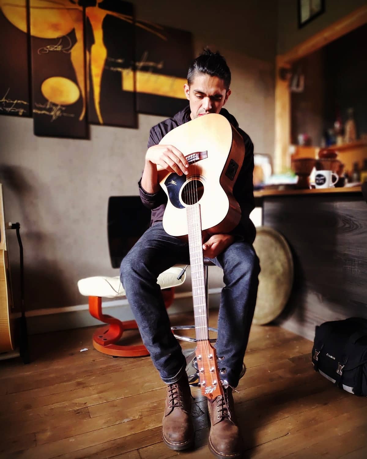 photo de Bernardo Martinez MB observant une guitare acoustisque